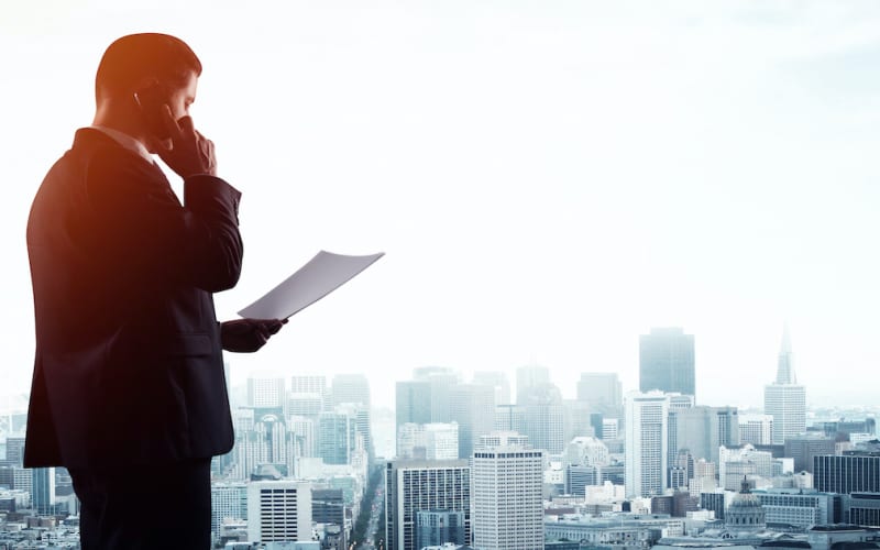 businessman with paper  and  talking on phone